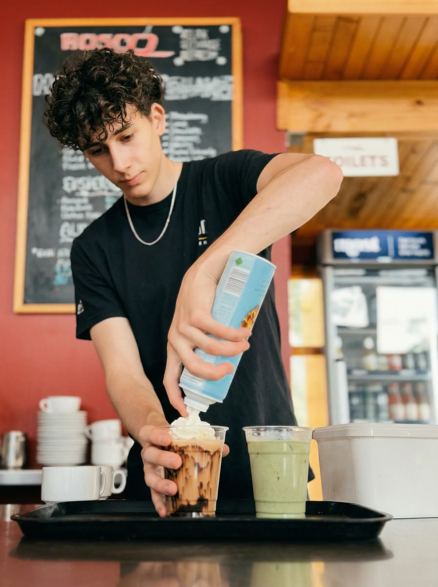 Barista preparing iced coffee and matcha drinks at Bosco Café, a popular cafe on SH3 Te Kūiti near Waitomo Caves